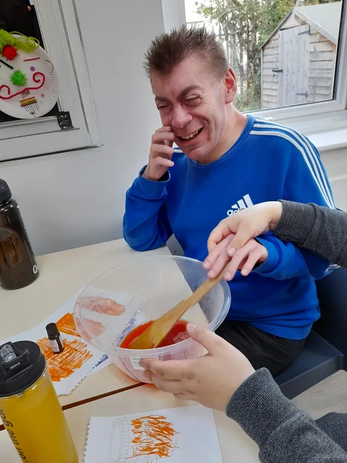A man is stirring jelly in a bowl