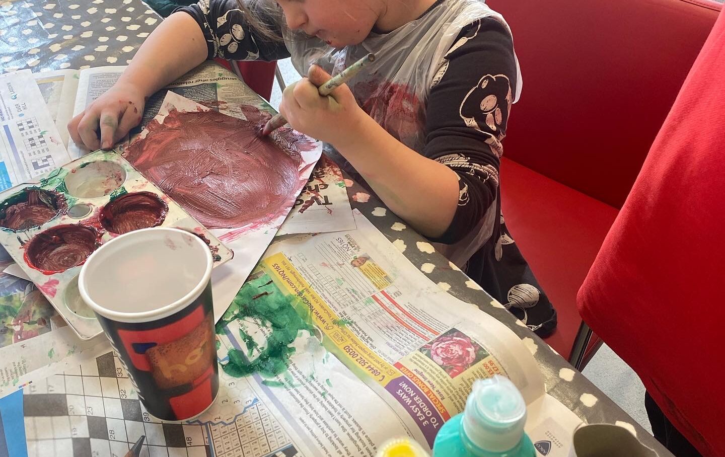 A girl is painting at a table.