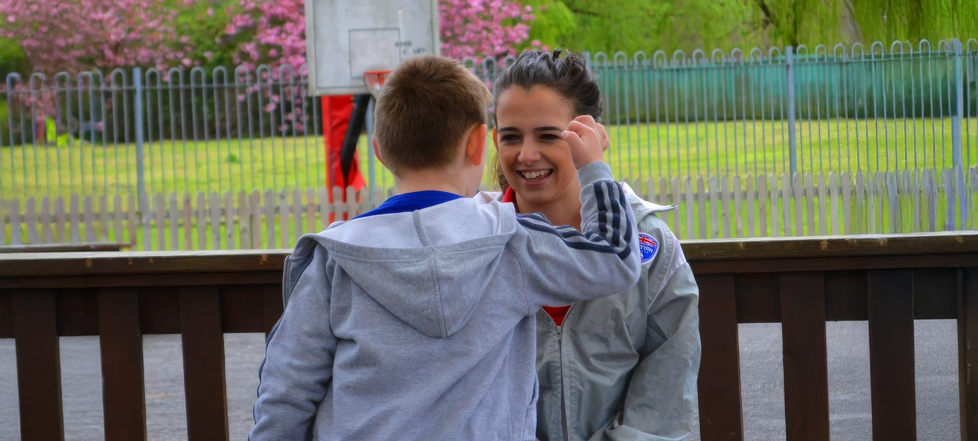 Service user and carer laughing and having fun in a grassy area
