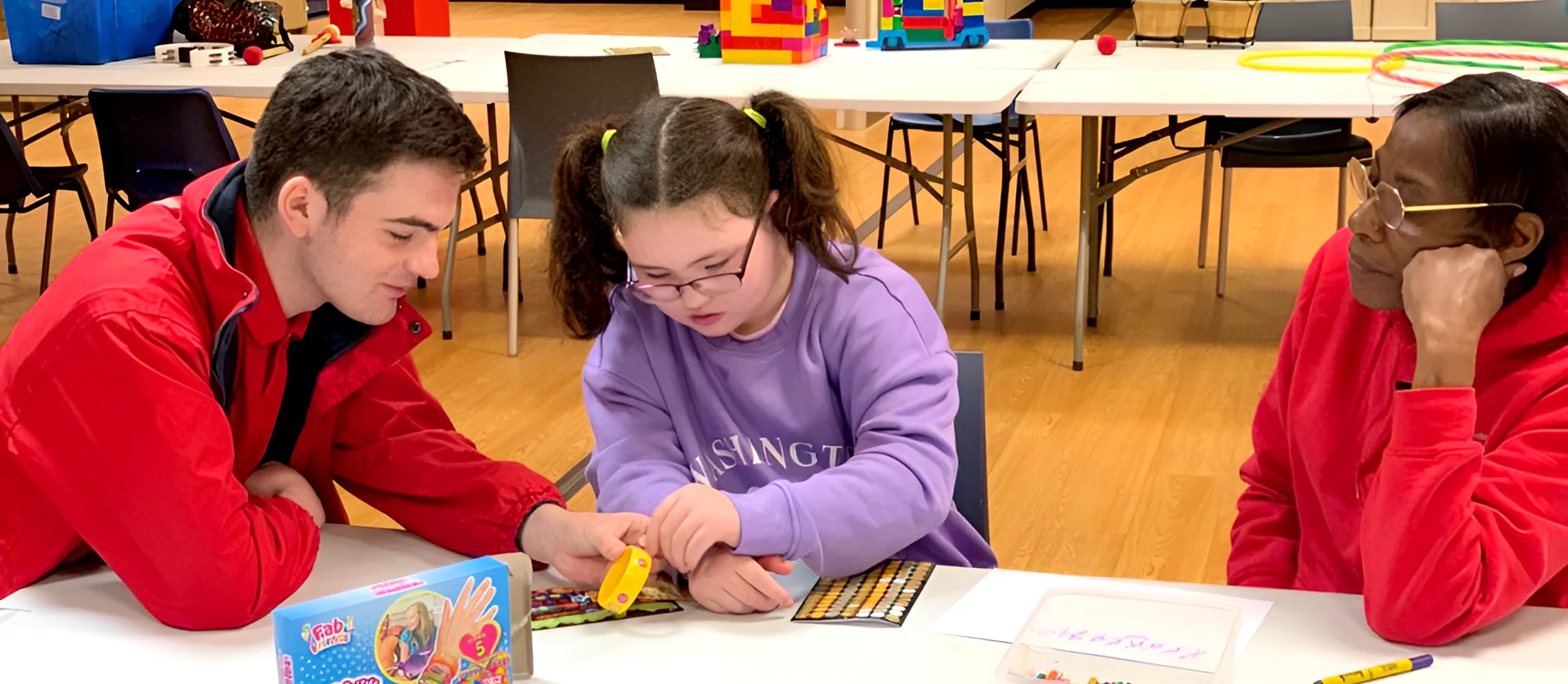 Support worker playing with a young service user at a table