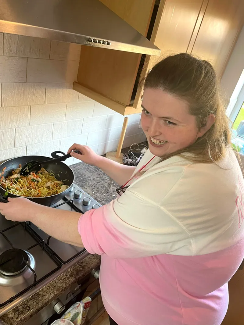 A service user cooking dinner at their Supported Living accommodation